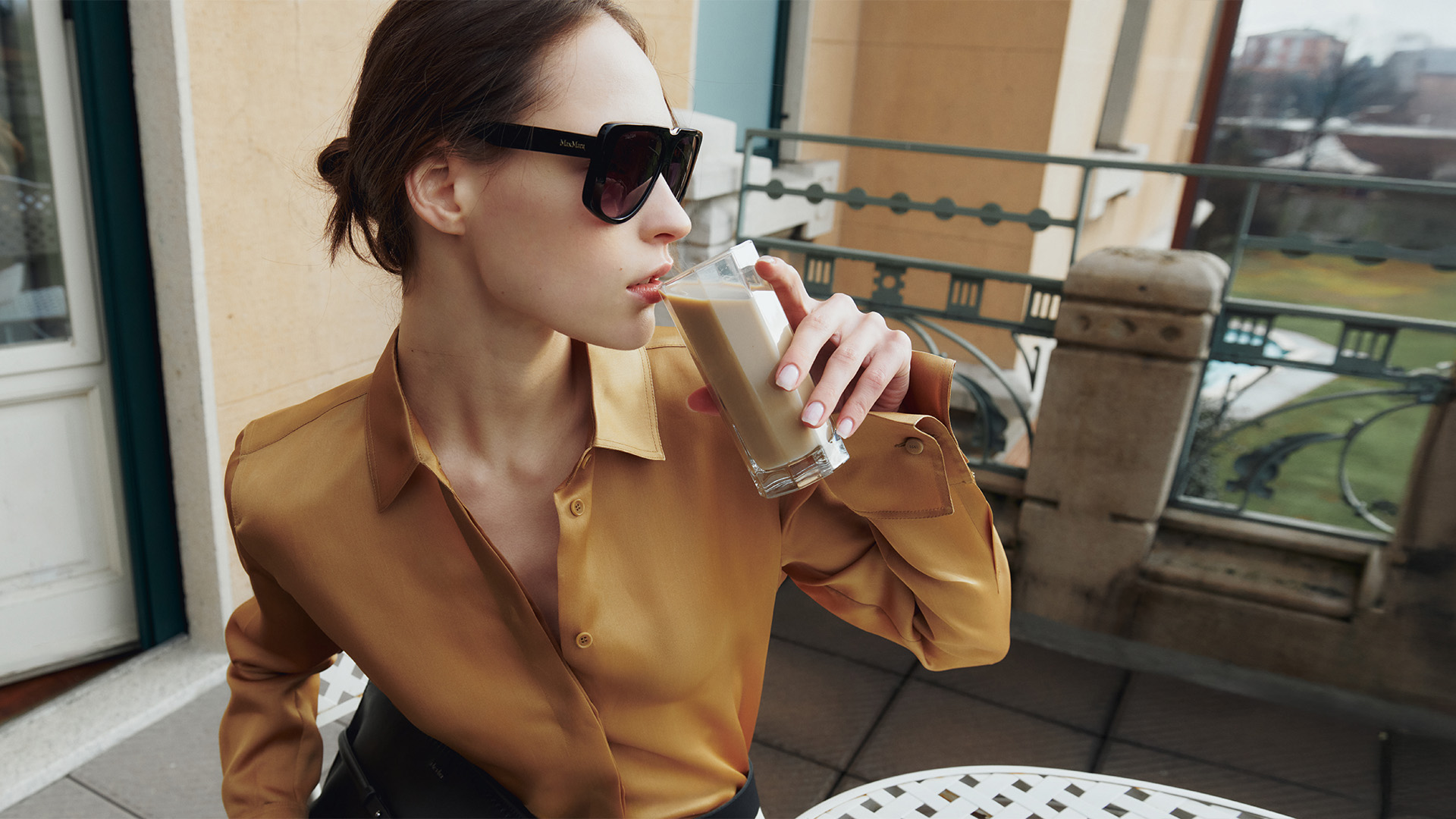 Modella indossa camicia satinata di colore giallo ocra